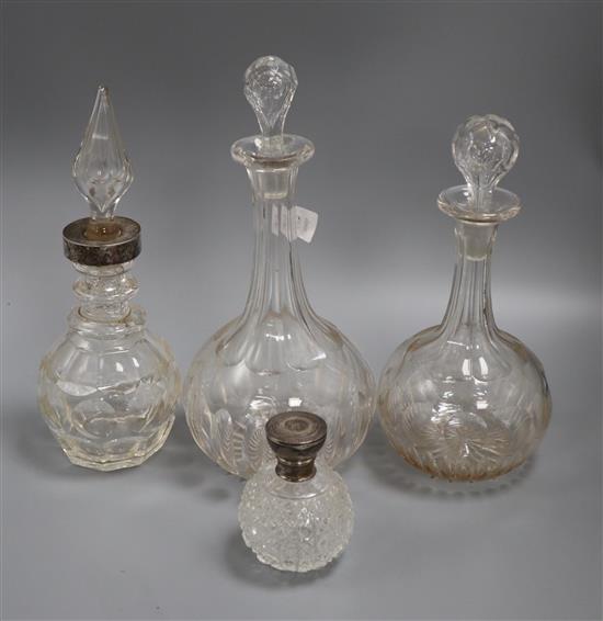 Three cut glass decanters and a silver mounted scent bottle